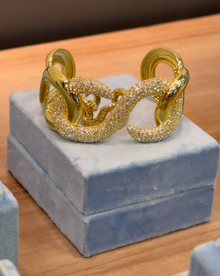 Bracelete dourado de elos cravejados exposto sobre caixa de veludo